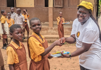 Marian Fueri shakes the hand of a student in an African village.