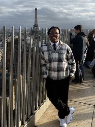 Raymond Miller stands with the Eiffel Tower in the background.