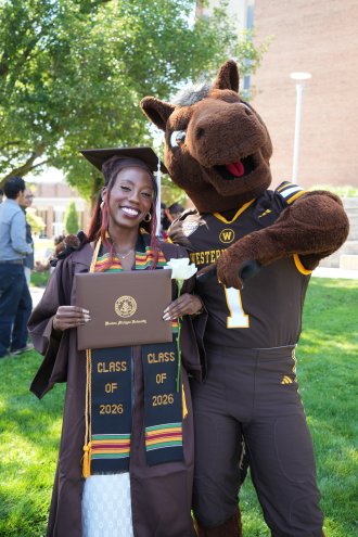 Shaniya Tate holds her degree next to Buster Bronco.