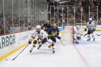 Hockey players got after a puck.