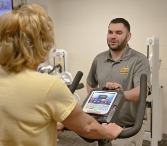 Physical Therapist assisting a patient with exercise equipment
