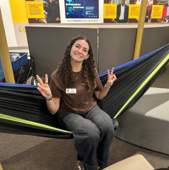 An honors student sits in a hammock in the Student Center. 