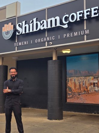 Talal Arshad, Western Michigan University alumnus and local business owner, poses outside of Shibam Coffee Co.