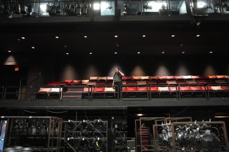 Abby Levin stands in a theatre balcony.