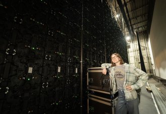 Amber Kolp stands next to audio equipment in a theater.