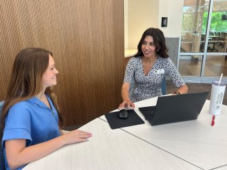 Honors advisor Yuri Estrada talks with an honors student about scheduling classes.
