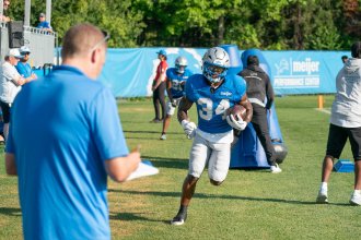 Detroit Lions senior writer Tim Twentyman observes team drills, writing observations in his notebook.