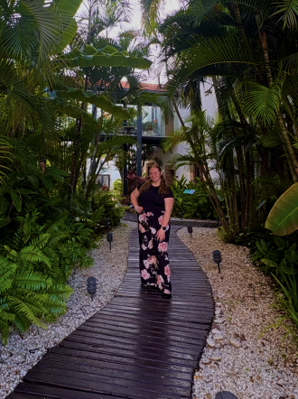 WMU study abroad student, Sara Stokely, stands for a photo on a path in front of palm trees in the Dominican Republic. 