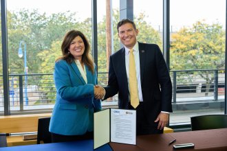 GRCC and WMU's presidents shake hands.
