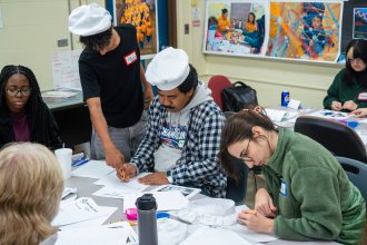 Students in chef hats planning activity