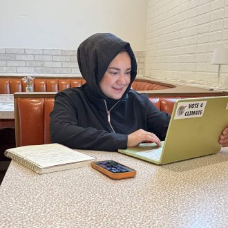 Fatma Dursunoğlu, a Western Michigan University alumna and local business owner, uses her laptop to work on research.