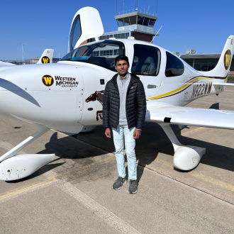 Student pilot in front of plane.