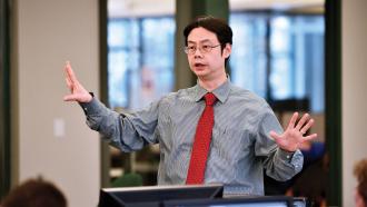 Dr. Kuanchin (KC) Chen standing in classroom