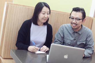 qi and qian working on a laptop
