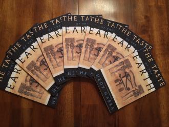 Numerous copies of The Taste of the Earth book fanned out in a half circle
