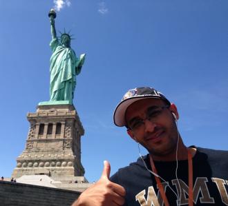 Ali Neamah in front of statue of liberty