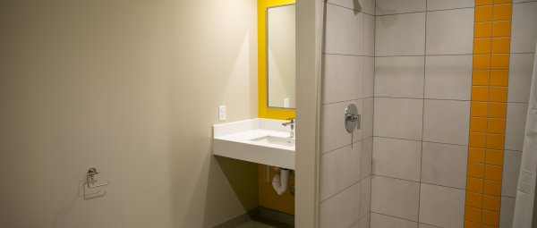 A single-occupancy bathroom featuring a toilet, a sink, and a shower.