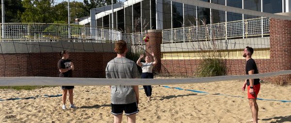 Group of student playing volleyball outside the Student Recreation Center