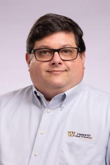 A professional headshot of Alan Rea