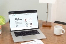 Image of laptop with EvaluATE homscreen and a cup of coffee on the desk