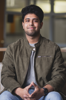 Headshot of Raiyan Wasi in a green jacket, grey shirt, and blue jeans