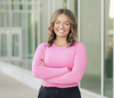 Photo of Madison Sedmak in front of Sangren hall in a pink shirt and black pants