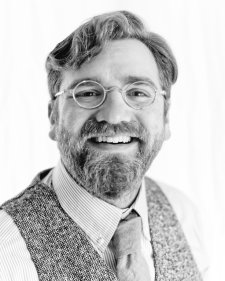 Black and white photo of Aaron Kates in a tie and vest