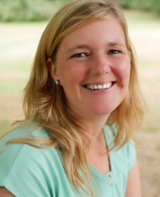 Professional photo of Goele Scheers outside smiling, wearing a green shirt.