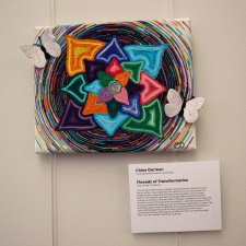 Glue, string, and cardboard art titled "Threads of Transformation."