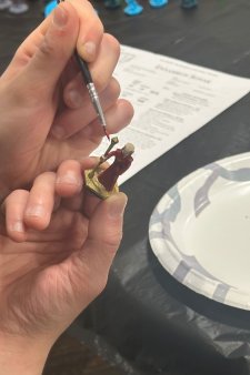 A student paints a mini figure to use in a 3D&D Adventure game at Waldo Library.