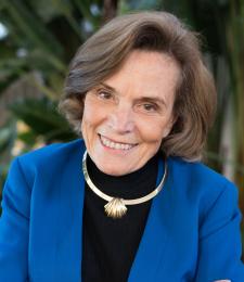 Head and shoulders portrait of an older woman wearing a black turtle neck and blue jacket.
