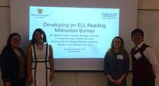 students posing in front of a presentation